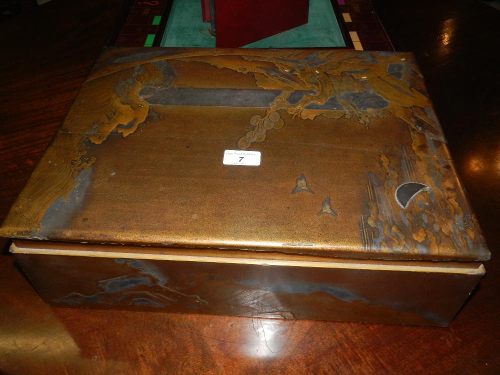 A Japanese lacquered picnic box of rectangular form decorated in relief with scene of the sea