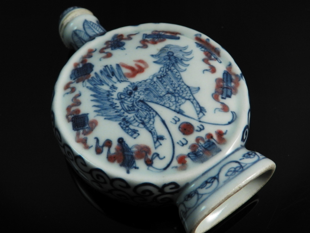 A 19th century snuff bottle of compressed spherical form decorated with dragons to the sides