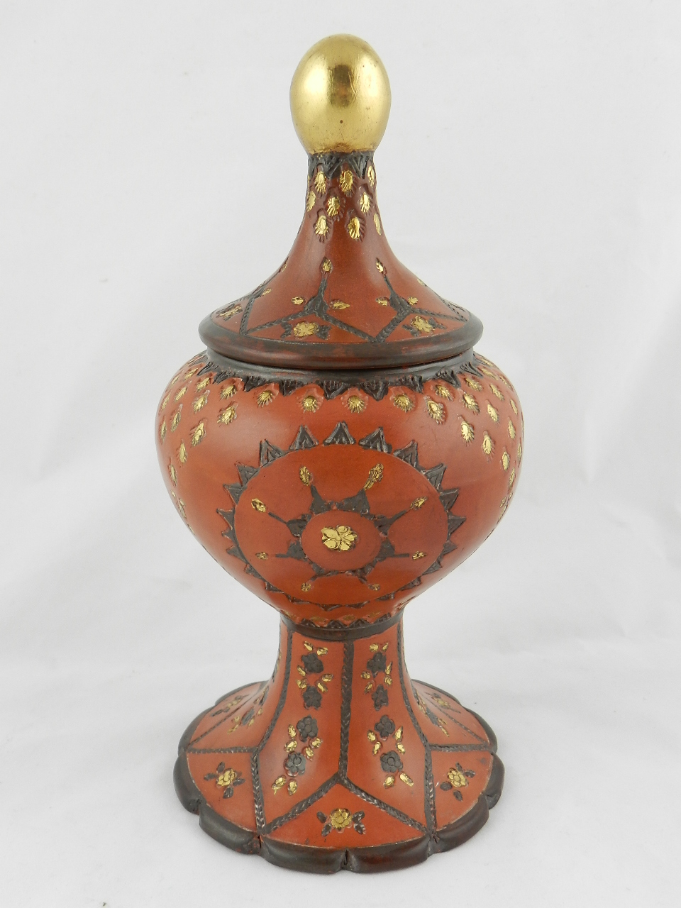 A Turkish terracotta sweet container of baluster form on raised spreading base the pull-off cover