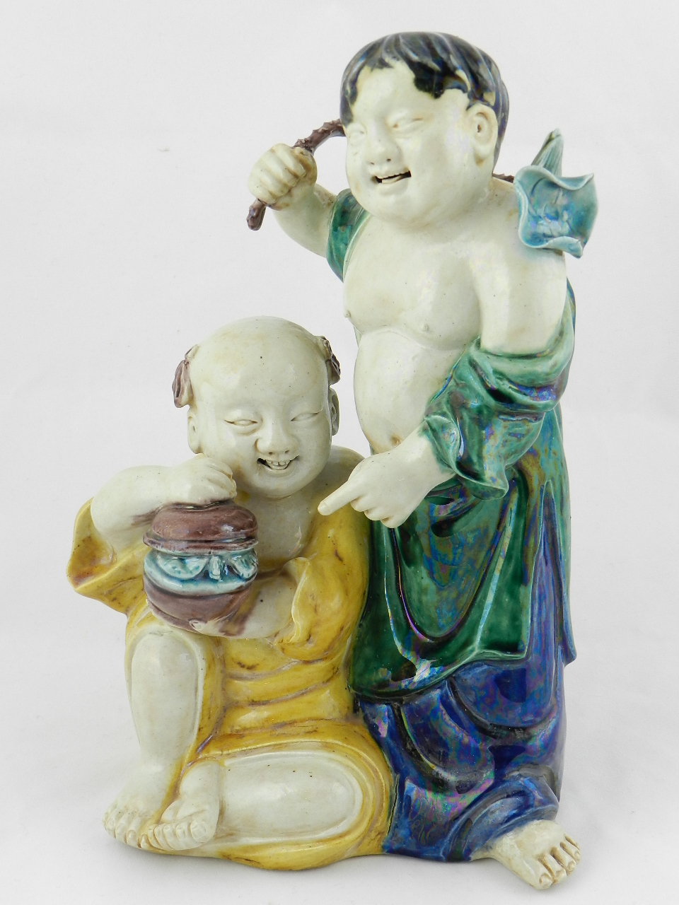 A Chinese ceramic group of two boys with a pot of food