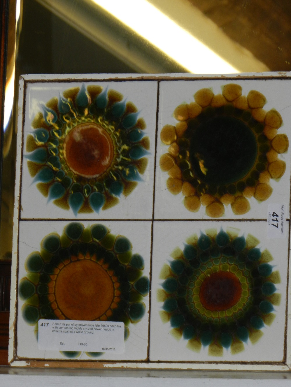 A four tile panel by provenance late 1960s each tile with contrasting highly stylized flower heads