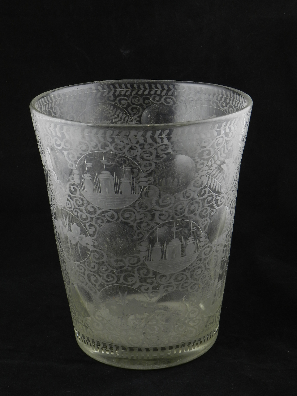 A large 19th century glass ice bucket/vase hand etched with various panels and leaf designs.