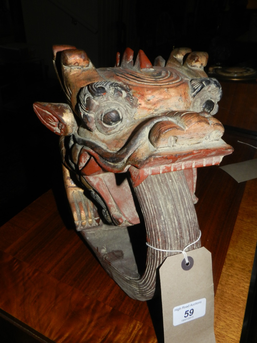 A Chinese carved and painted wooden dragons head with extended tongue