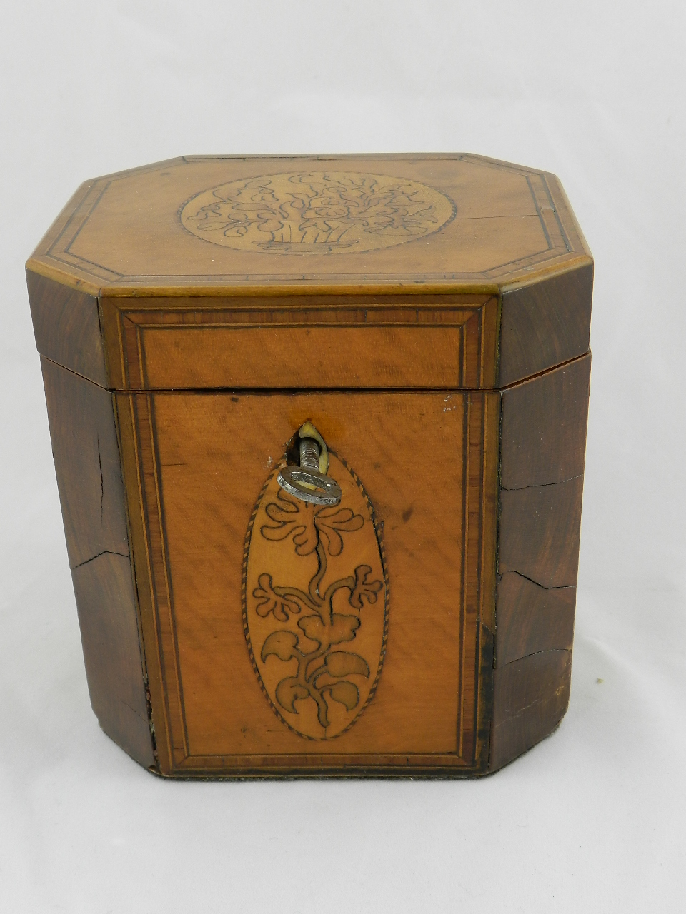 A late 18th century/early 19th century octagonal fruitwood inlaid tea caddy decorated with floral