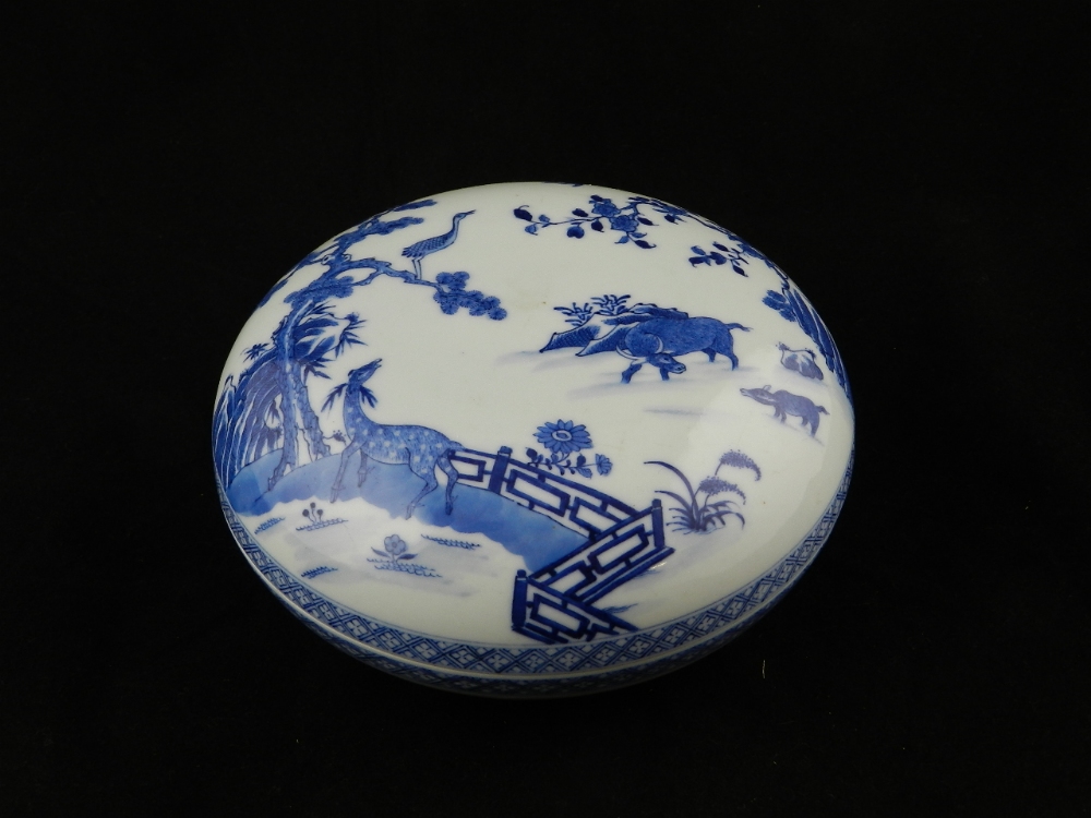 A Chinese blue and white ceramic box of compressed circular form decorated with horses, birds and