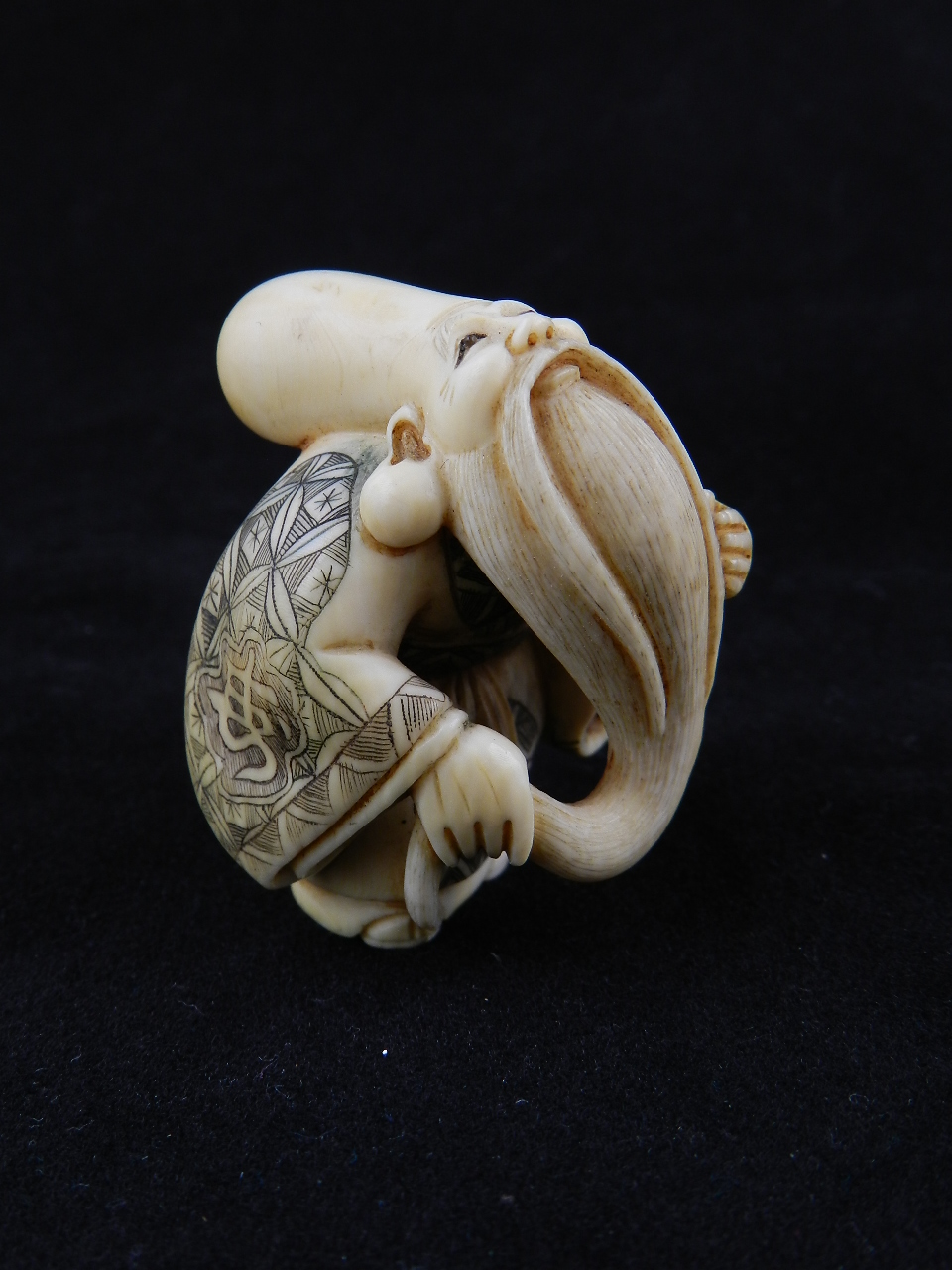 An ivory netsuke in the form of a sage bearing signature to the base