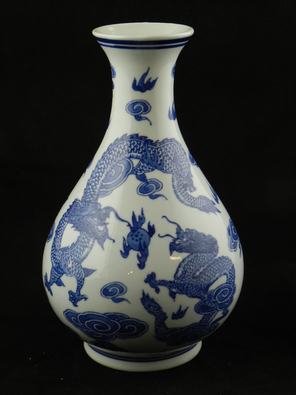 An oriental blue and white porcelain vase decorated with flying dragons and flaming pearls