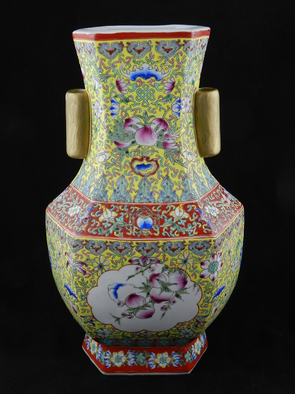 A 20th century vase of hexagonal form profusely decorated with flowers fruits leaves and scrolls.