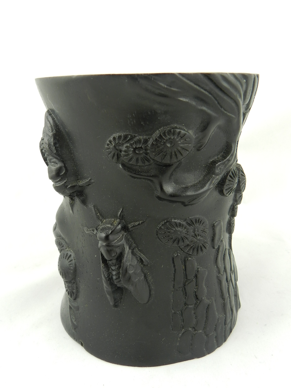A Chinese carved hardwood brush pot relief decorated with flora and fauna.
