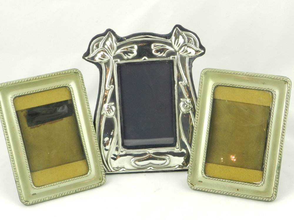 An art nouveau hall mark silver photograph frame together with two silver plated examples.