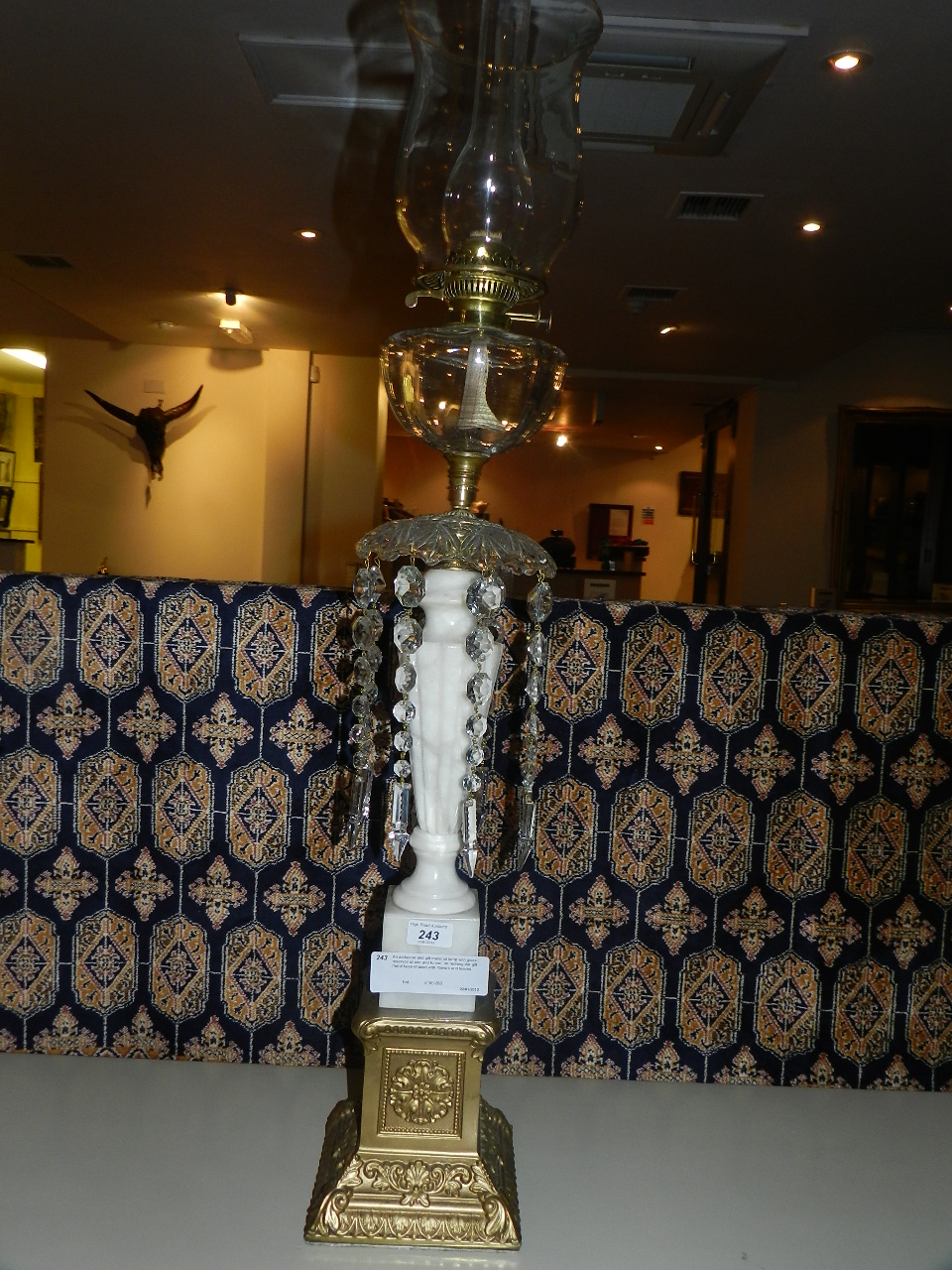 An alabaster and gilt metal oil lamp with glass reservoir shade and funnel, on rectangular gilt