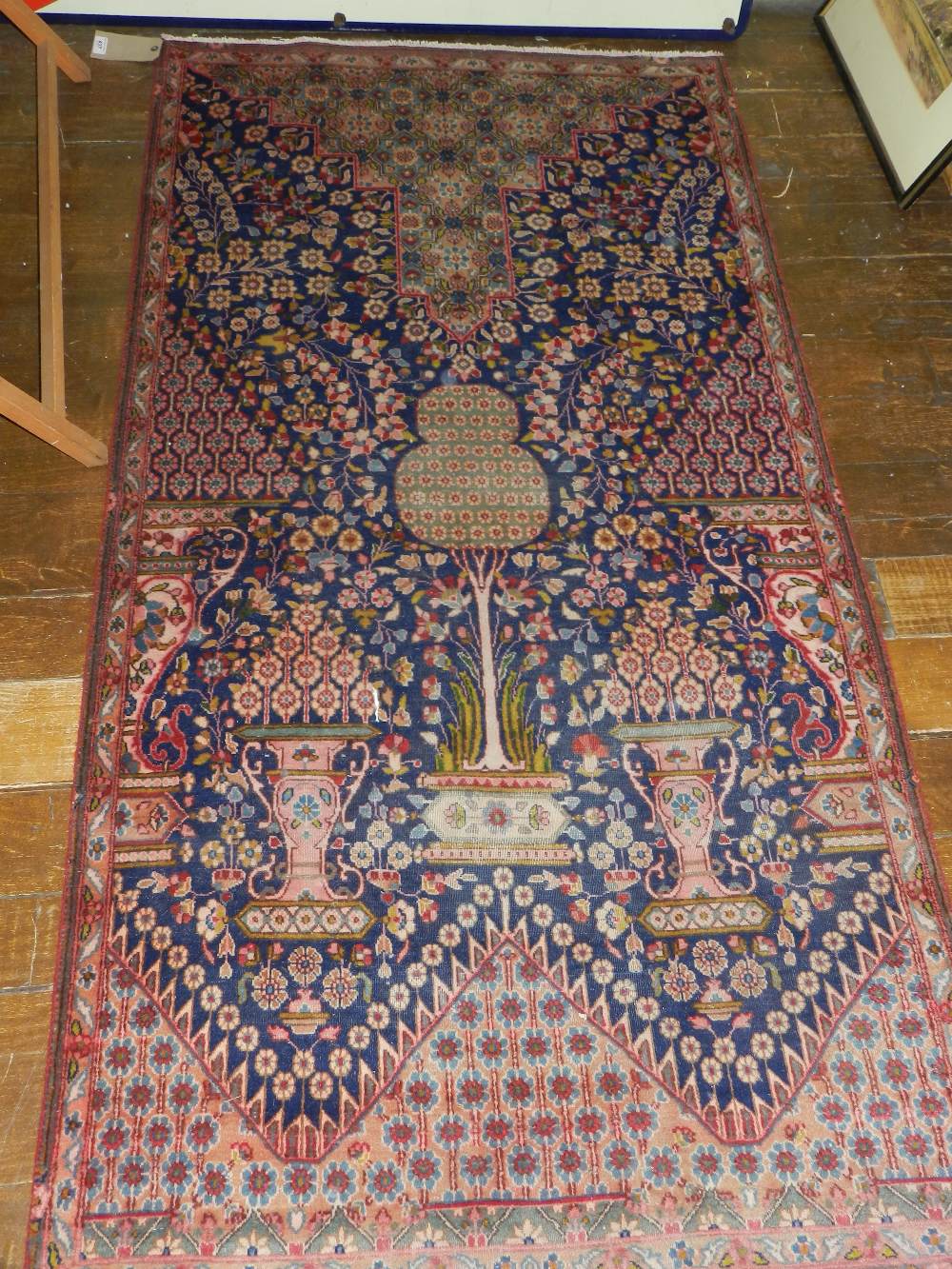 A Kirman rug having vase of flowers designs on a cobalt blue ground contained by borders