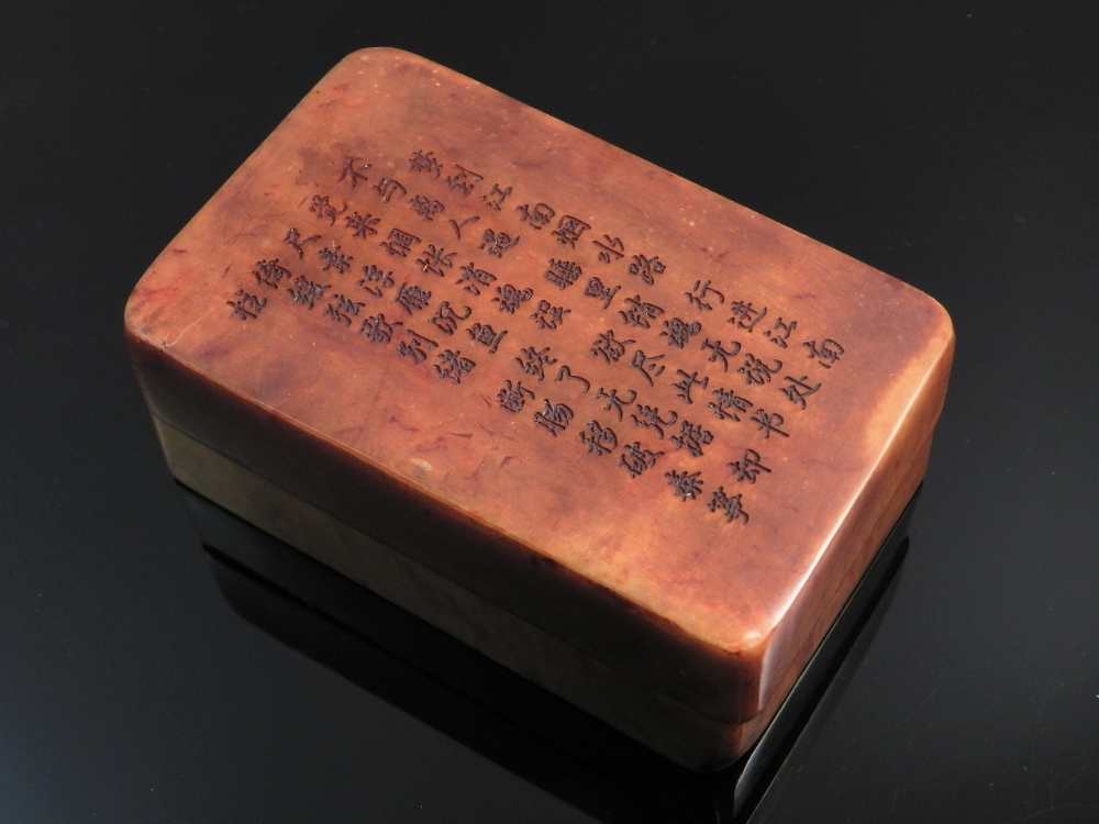 A Chinese carved soapstone seal box containing two seals decorated with character marks.