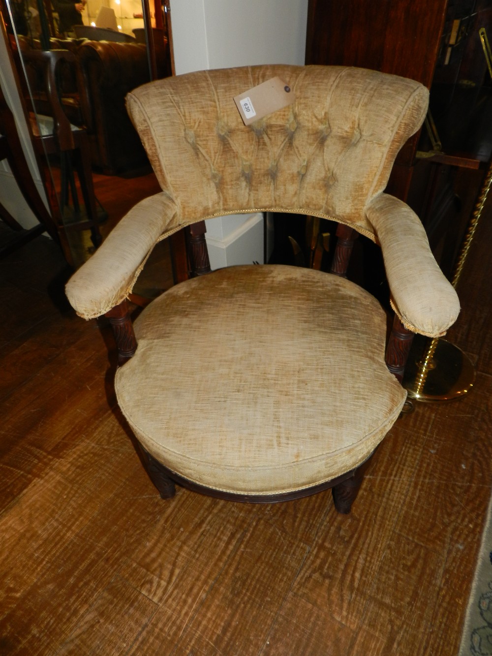 A mahogany framed tub chair button back upholstered with gold fabric.