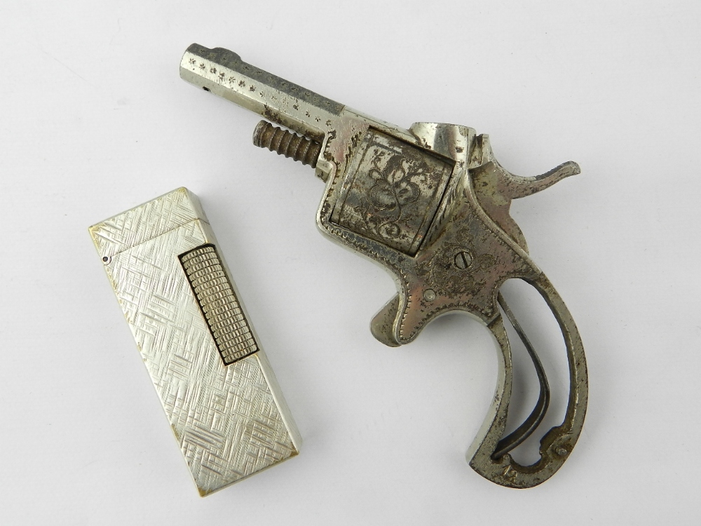 A Dunhill roller gas lighter together with a Victorian cigar piercer in the form of a revolver.