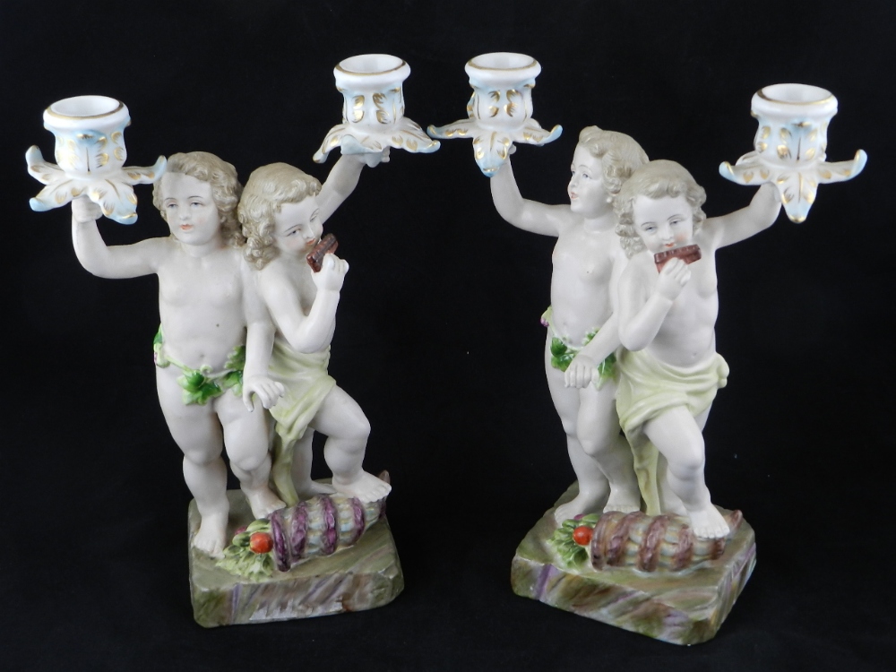 A pair of continental porcelain horn branch candle holders in the form of musical patterns.