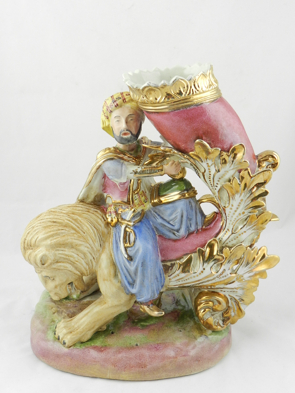 A French group of a sultan riding a lion with vase form cornucopia all on an oval base.