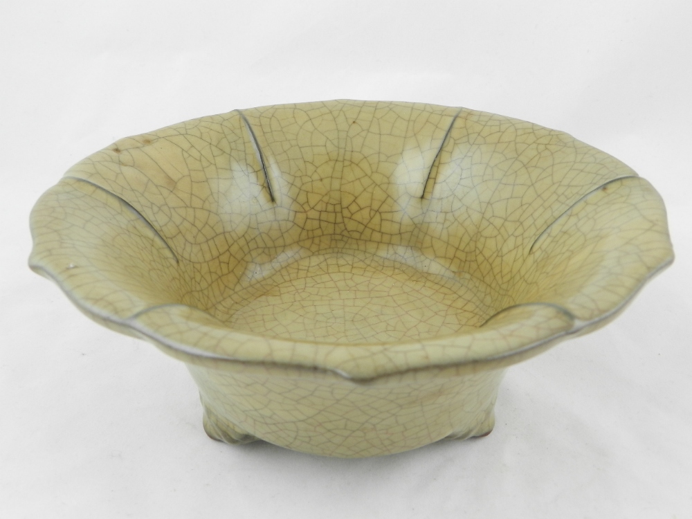 A Chinese crackle glazed porcelain bowl raised on triform supports.