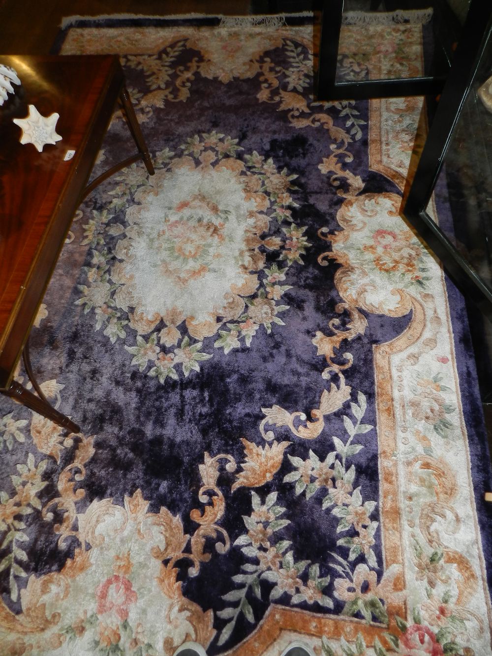 An oriental silky carpet having central floral medallion on a purple ground contained by a floral