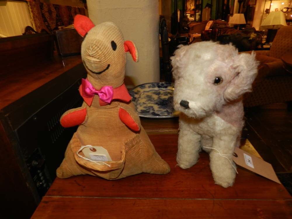 A queens stuffed kangaroo with red ears, paws and collar and a stuffed seated dog with glass eyes
