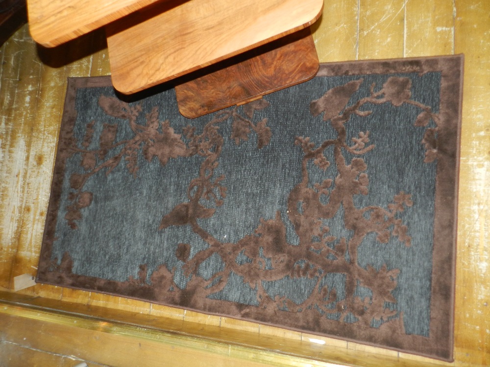 A contemporary rug with raised brown tree designs on a blue ground.