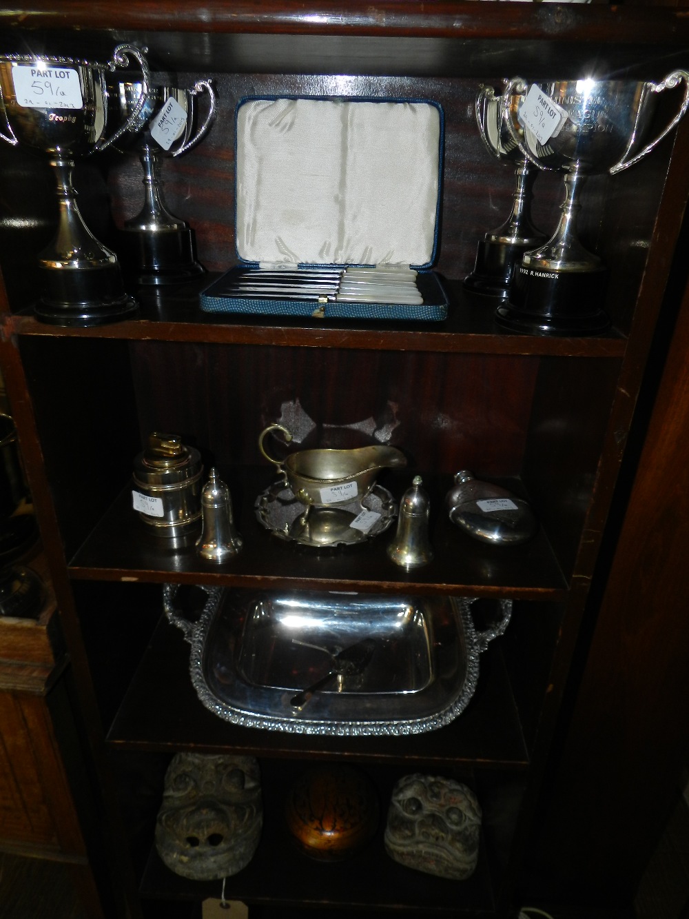 An Old Sheffield Plate cake basket, four plated trophy cups, a plated card tray, a sauce boat, table