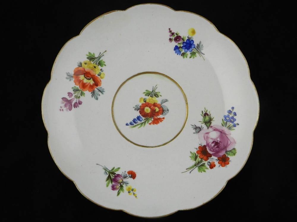 An 18th century Meissen plate decorated with sprays of flowers.