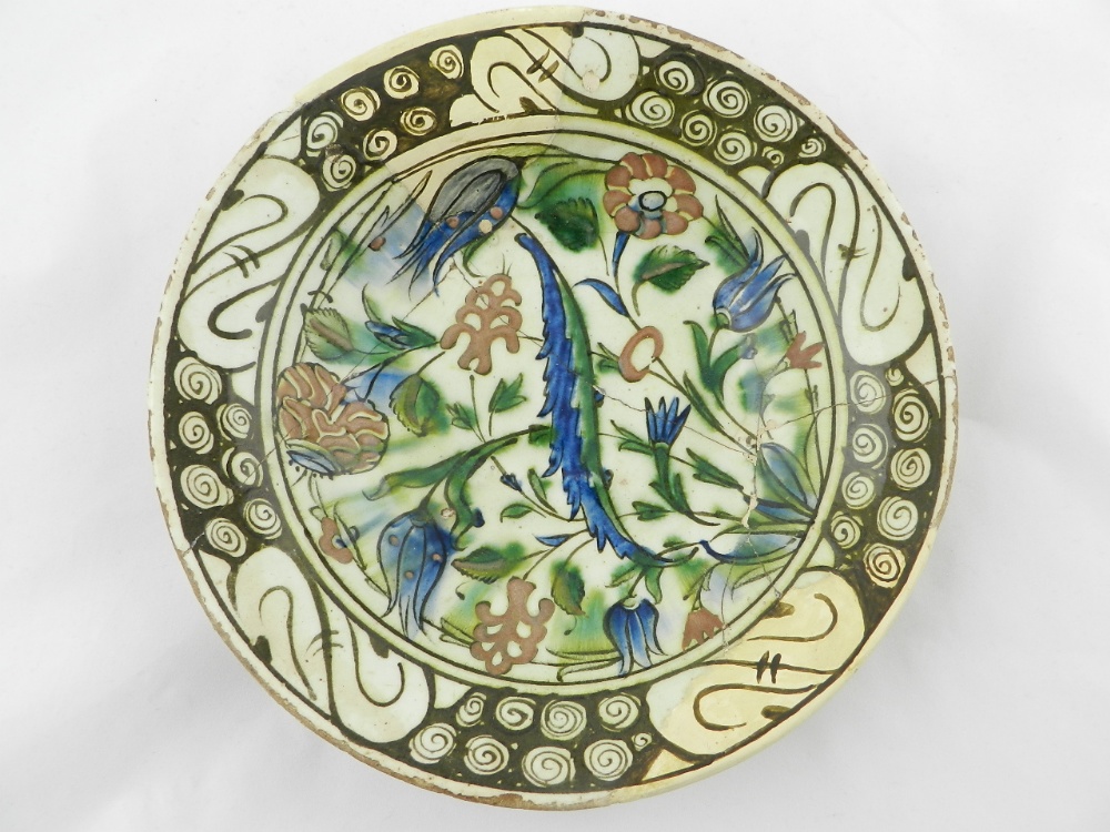 A 17th Century Iznik Ottoman Turkish polychromatic `storm in a tea cup` plate decorated with saz