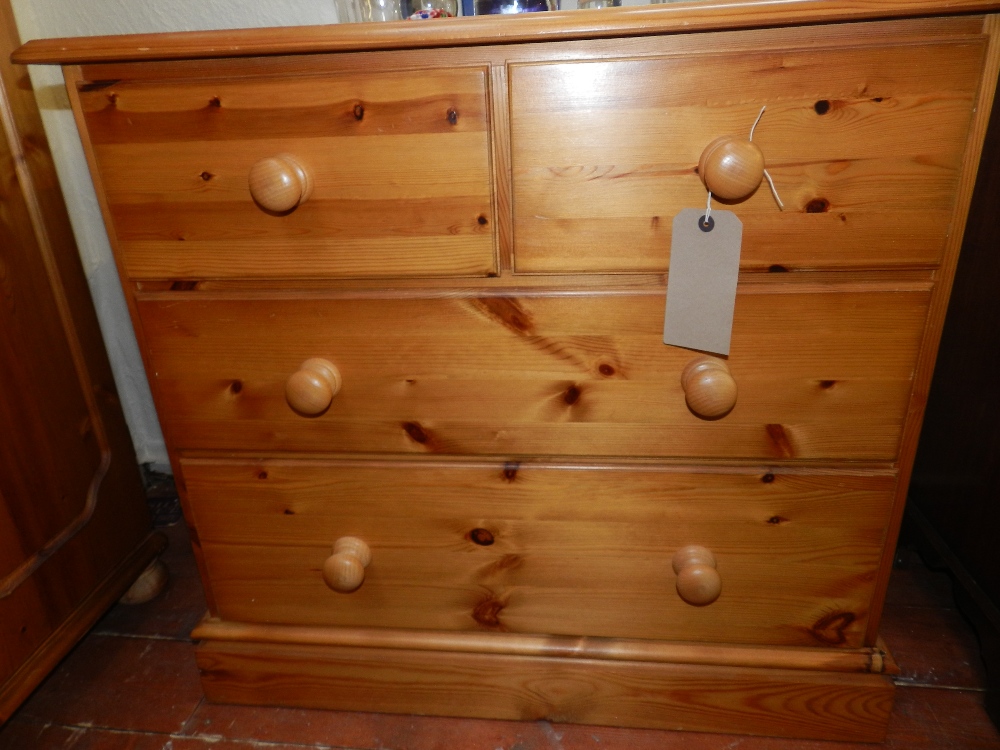 A small contemporary pine chest of drawers, having two small over two long drawers