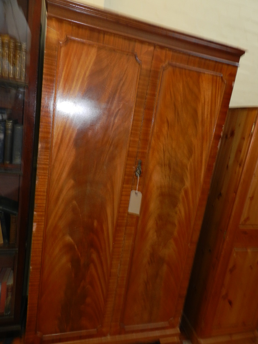 An Edwardian flame mahogany two door wardrobe, having shelve and rail.