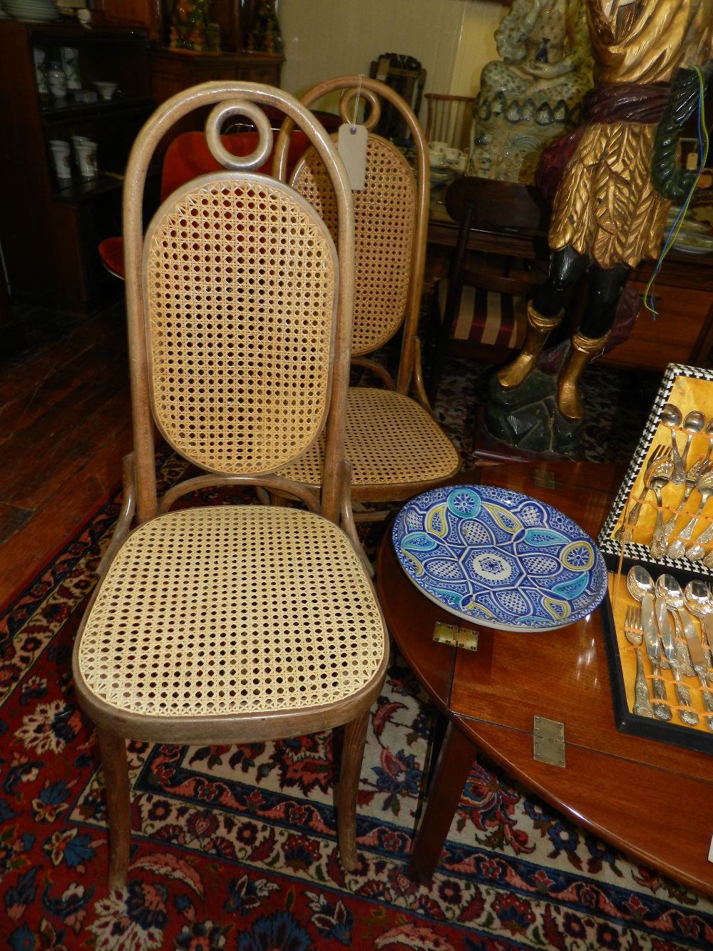 A set of four bentwood dining chairs having caned back rests and seats