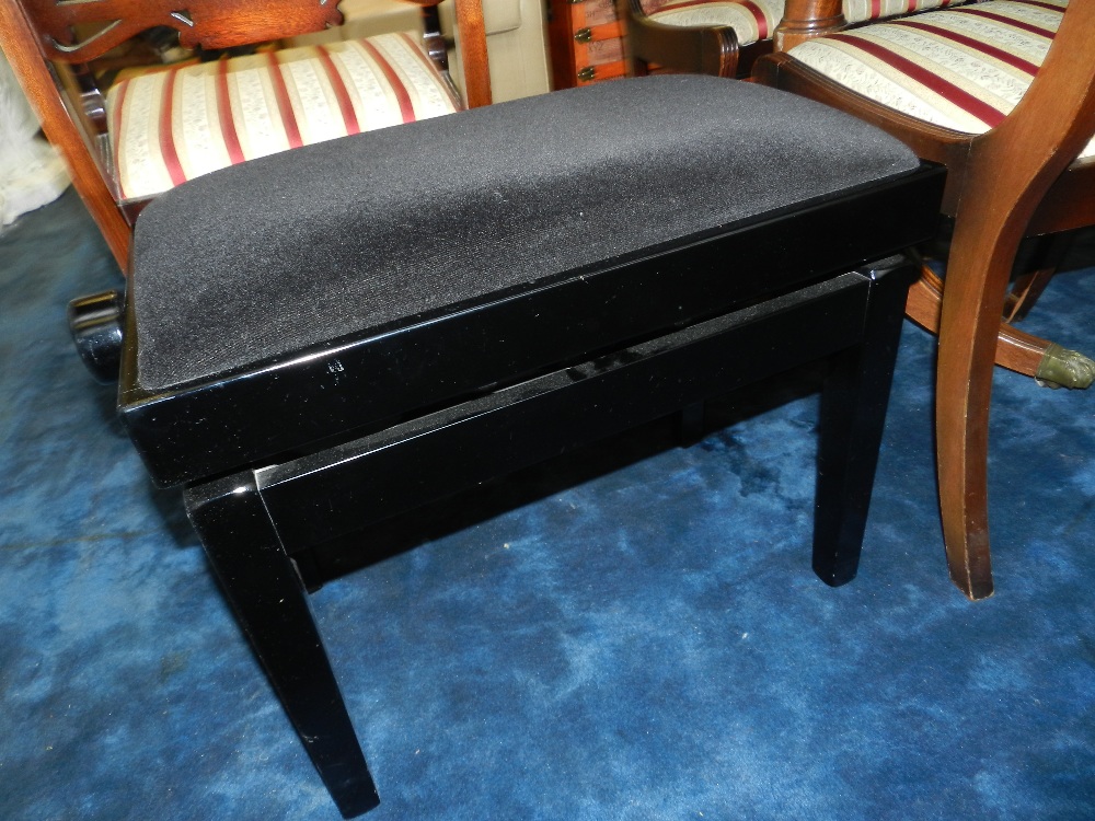 A black lacquer adjustable piano stool, upholstered in black velvet, from Steinway and Sons.
