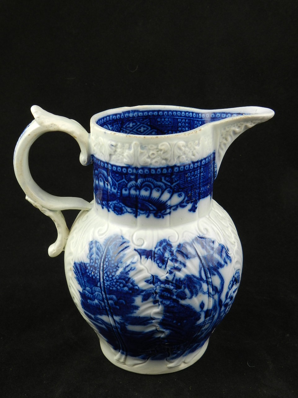 An 18th Century Liverpool blue and white jug double scroll handle with leaf mounted spout the