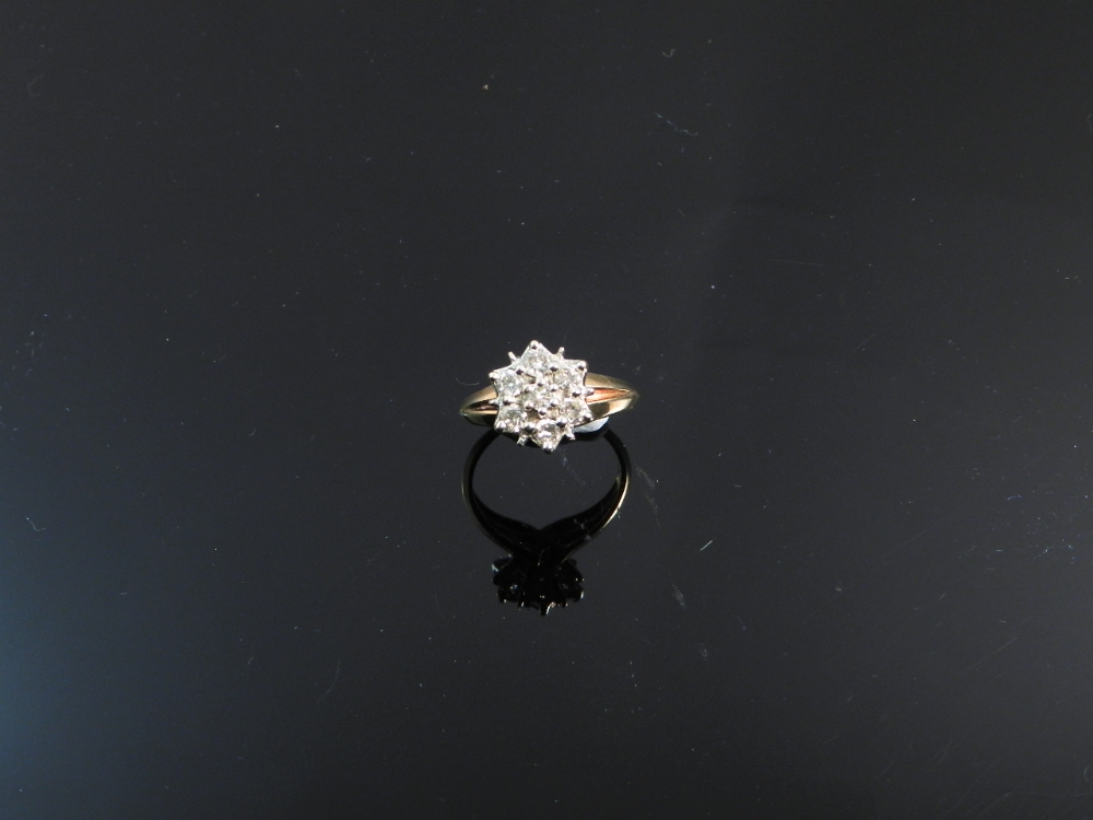 A 1970s vintage 9ct yellow gold ring, having a flower of seven diamonds mounted in platinum.