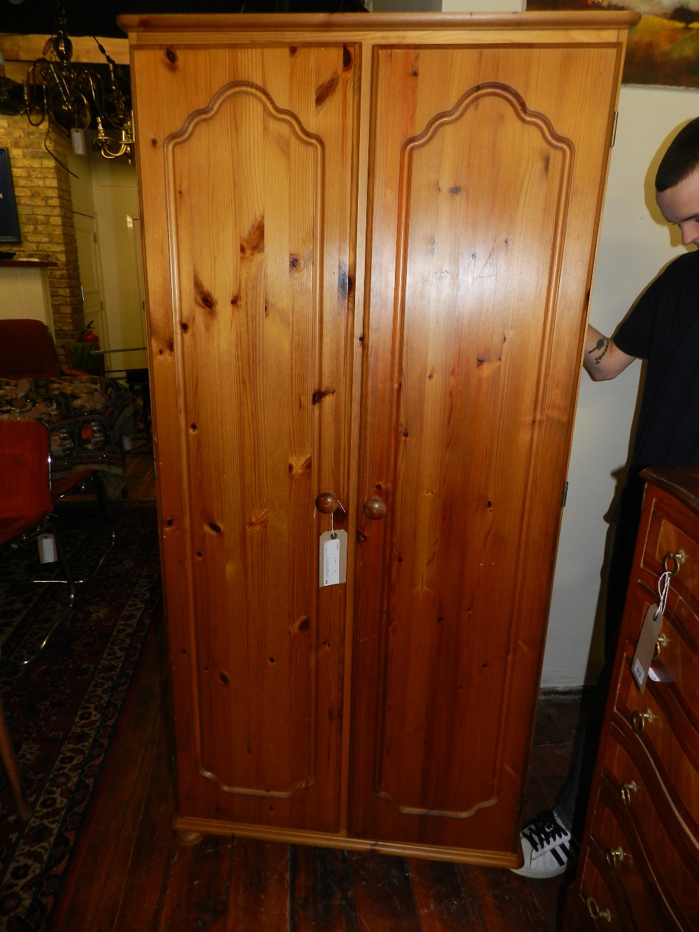 A contemporary panelled two door wardrobe, having bottom shelve and rail.