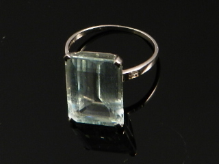 A 9ct white gold dress ring set with emerald cut clear stone (possibly aquamarine)