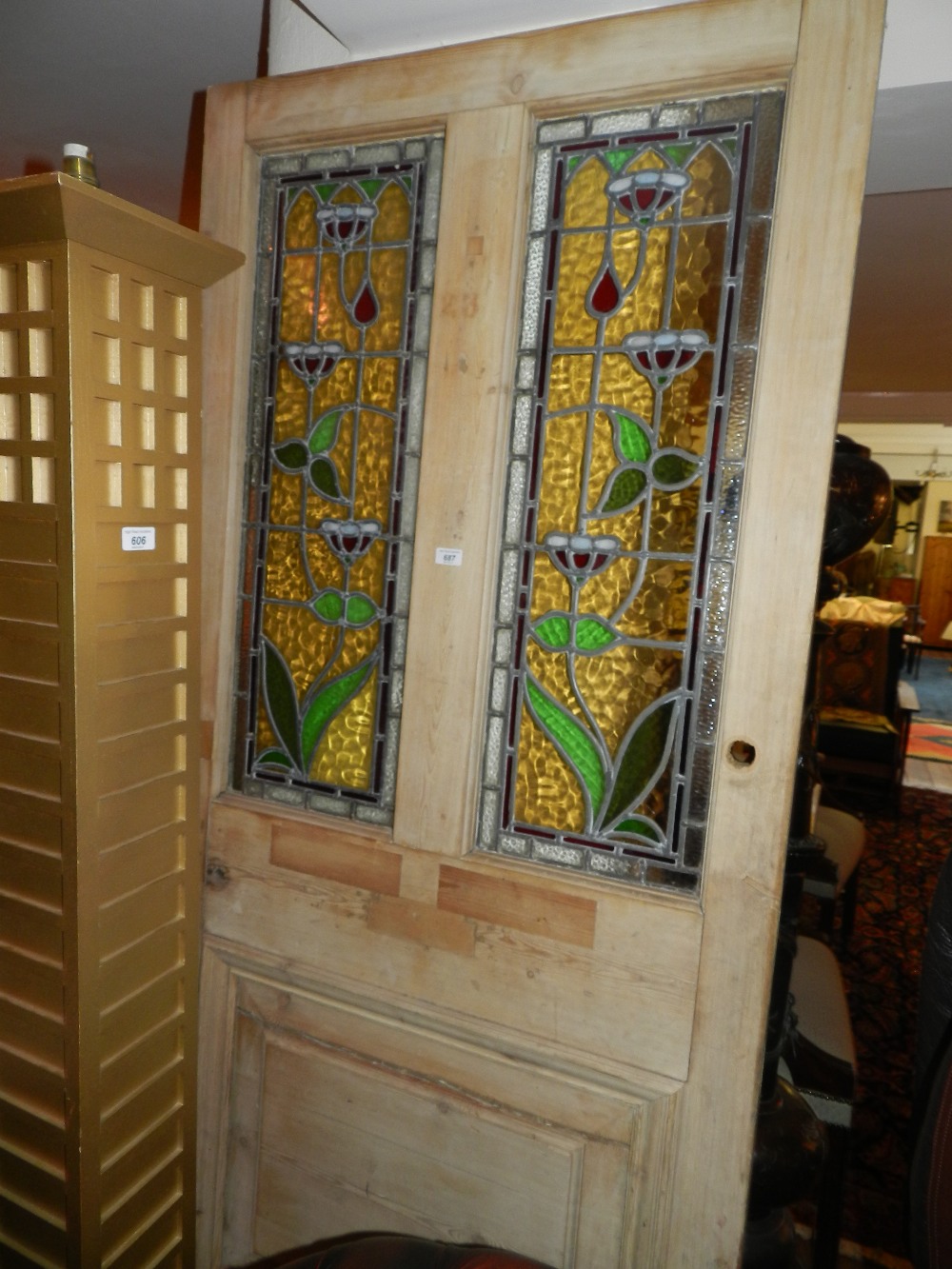 A large pine door inset with two art nouveau stained glass panels.