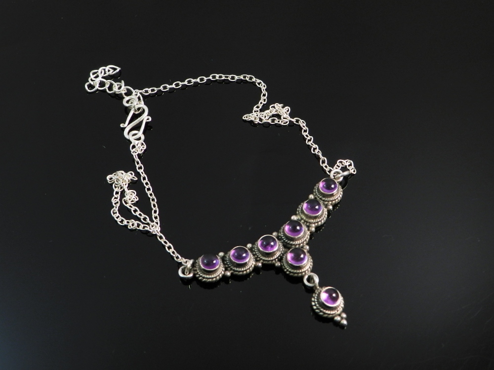 A sterling silver necklace set with amethyst jewels.