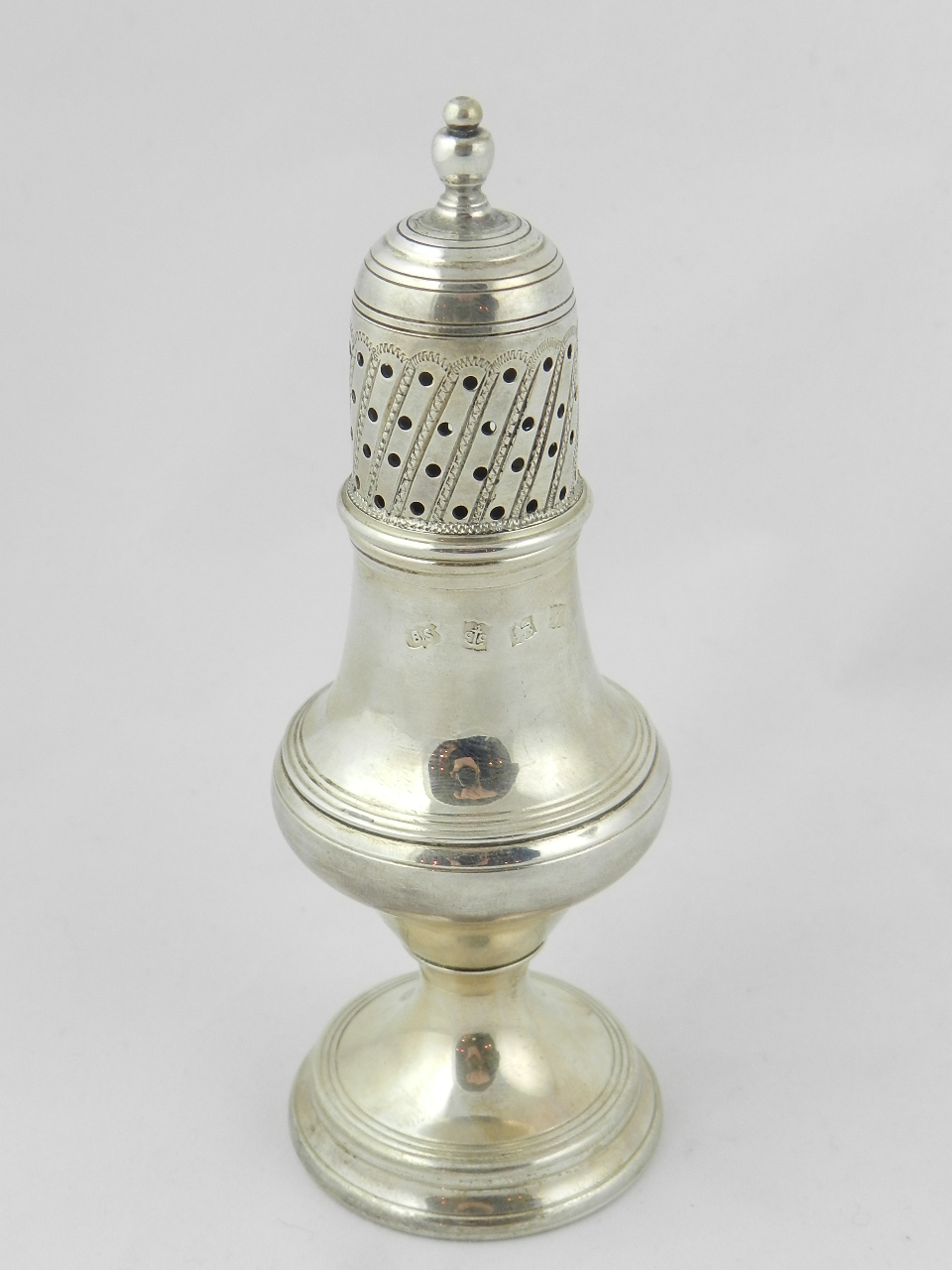 A George III style silver pepperette of baluster form with pierced pull off cover