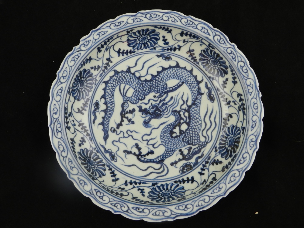 A Chinese blue and white porcelain dish decorated with dragon and floral designs.
