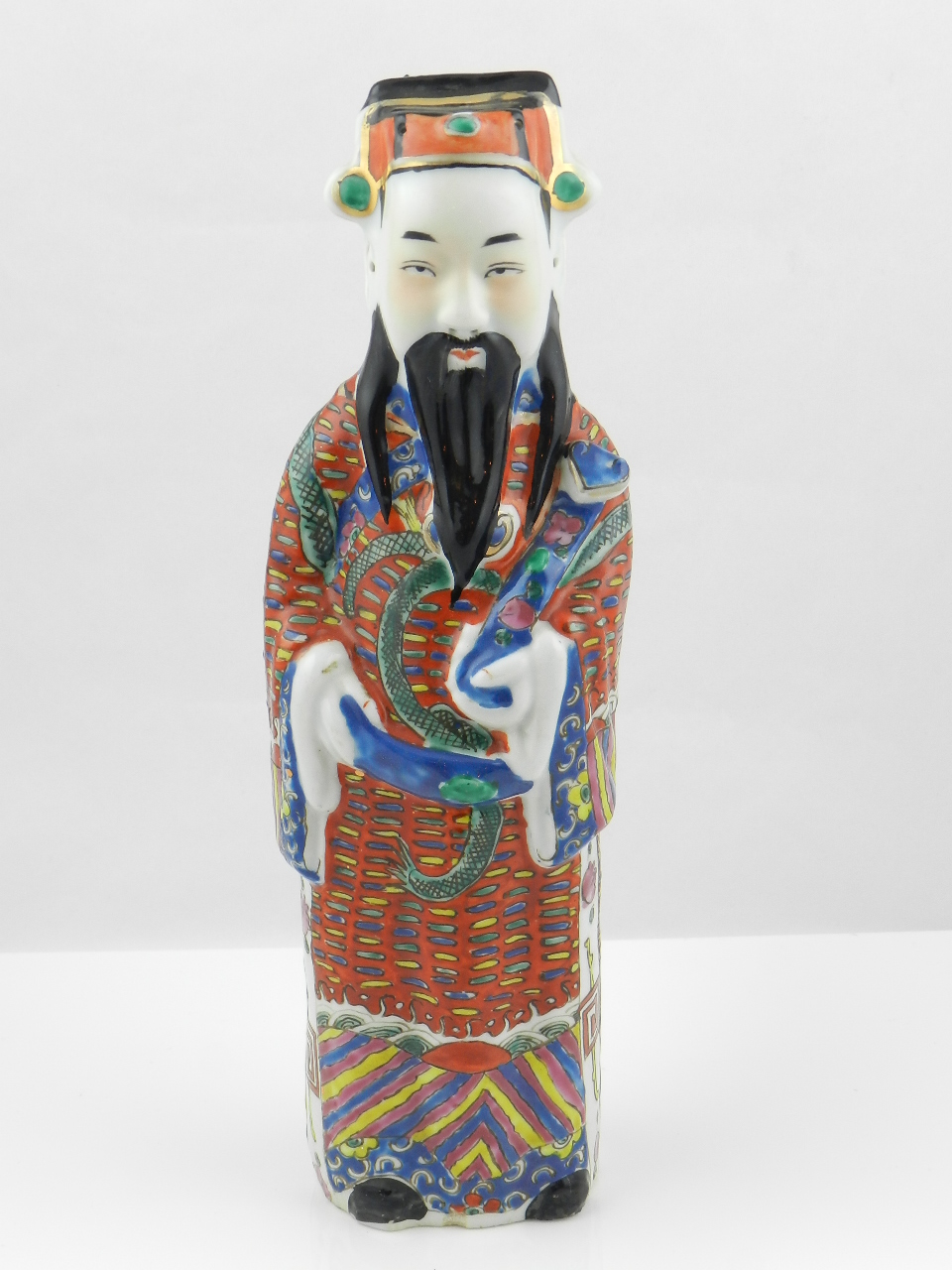 An oriental porcelain figure of a scholar along with three bronze Buddhas.