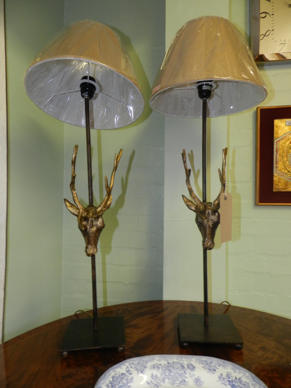 A pair of contemporary table lamps having applied stags head decoration.