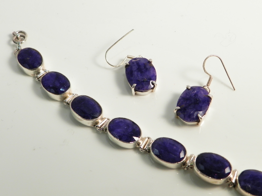 A sterling silver bracelet and earrings mounted with lapis lazuli.