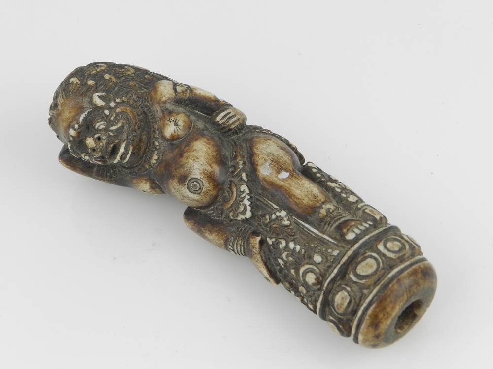 An Idonesian carved bone handle in the form of a demon