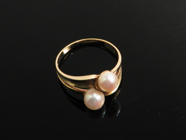 A 14ct yellow gold cross over ring set with two white pearls.