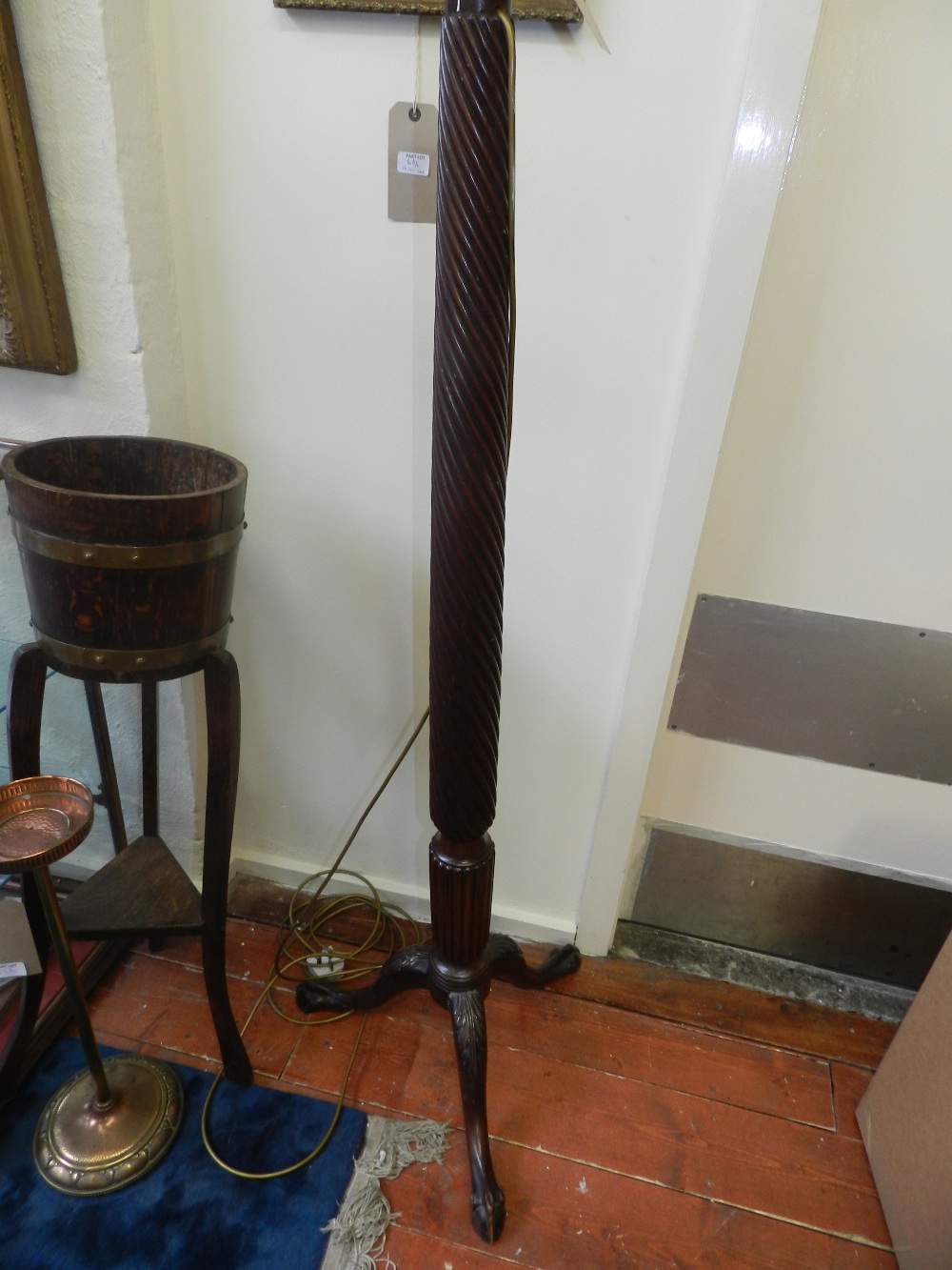 A 20th century mahogany standard lamp, spirally twisted on three leaf carved outswept legs with ball