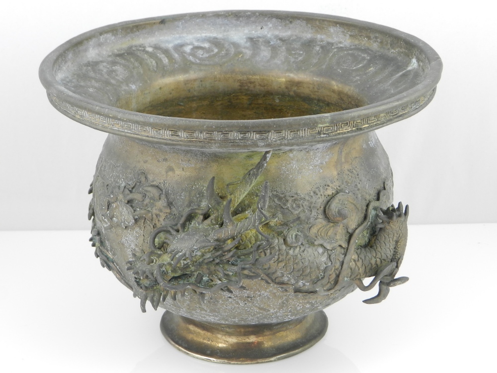 A large 19th century Chinese un-patinated bronze dragon vase with everted rim.