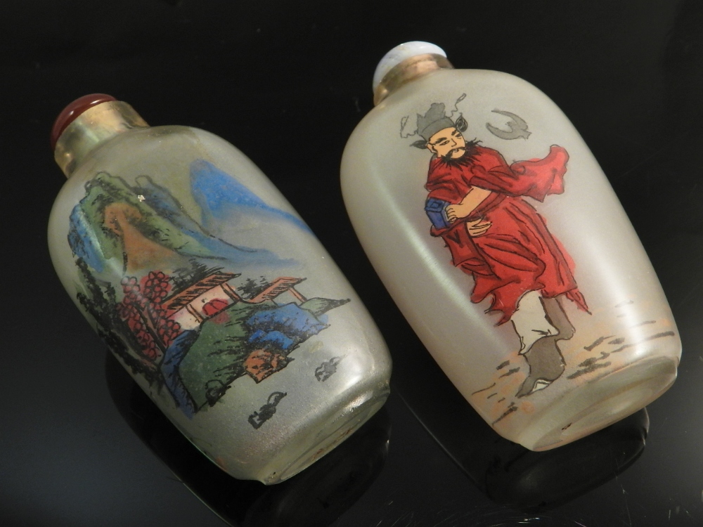 Two Chinese reverse glass painted snuff bottles decorated with figures and landscapes.