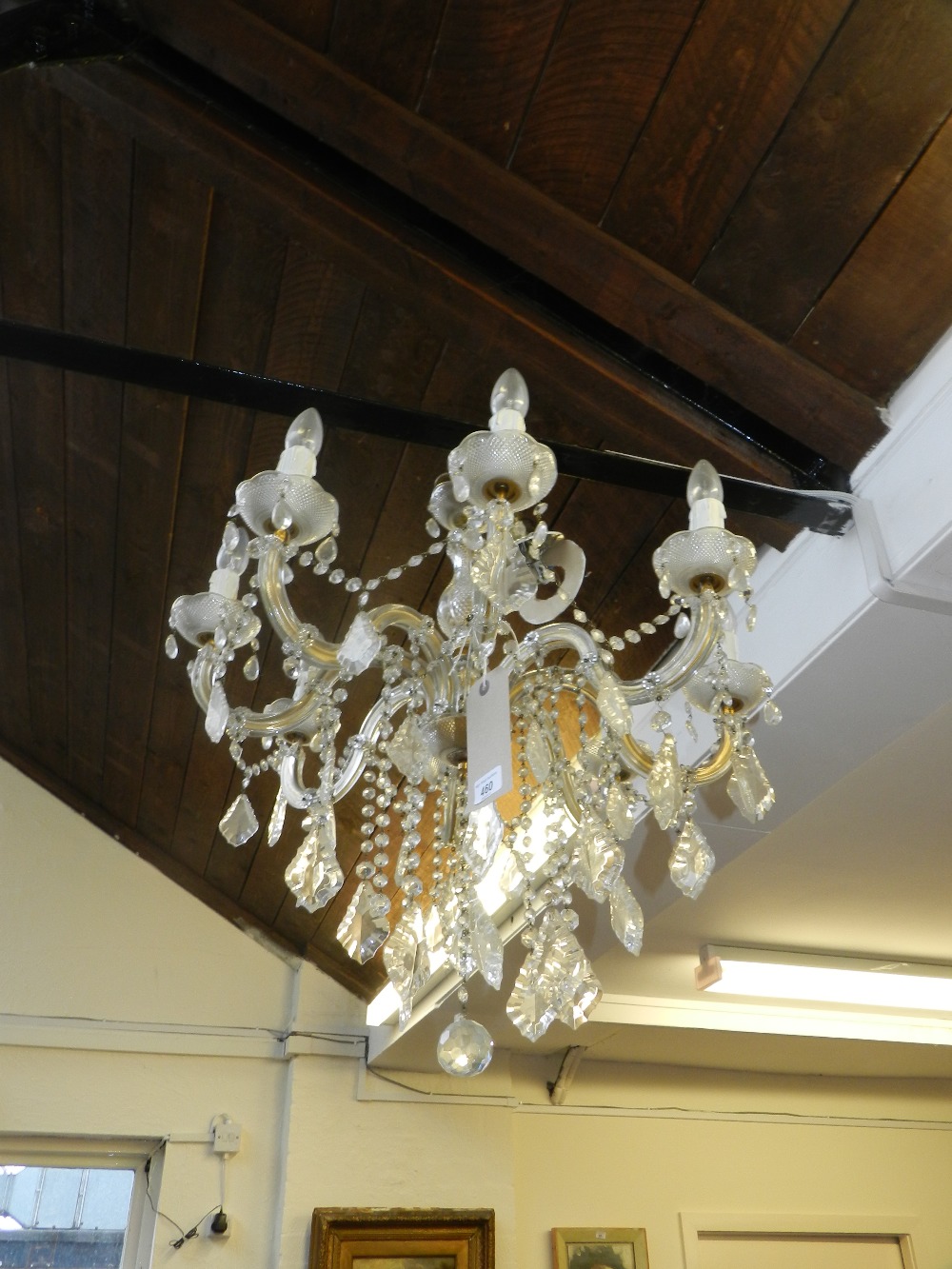 A crystal glass mounted eight branch electrolier festooned with swags and droplets.