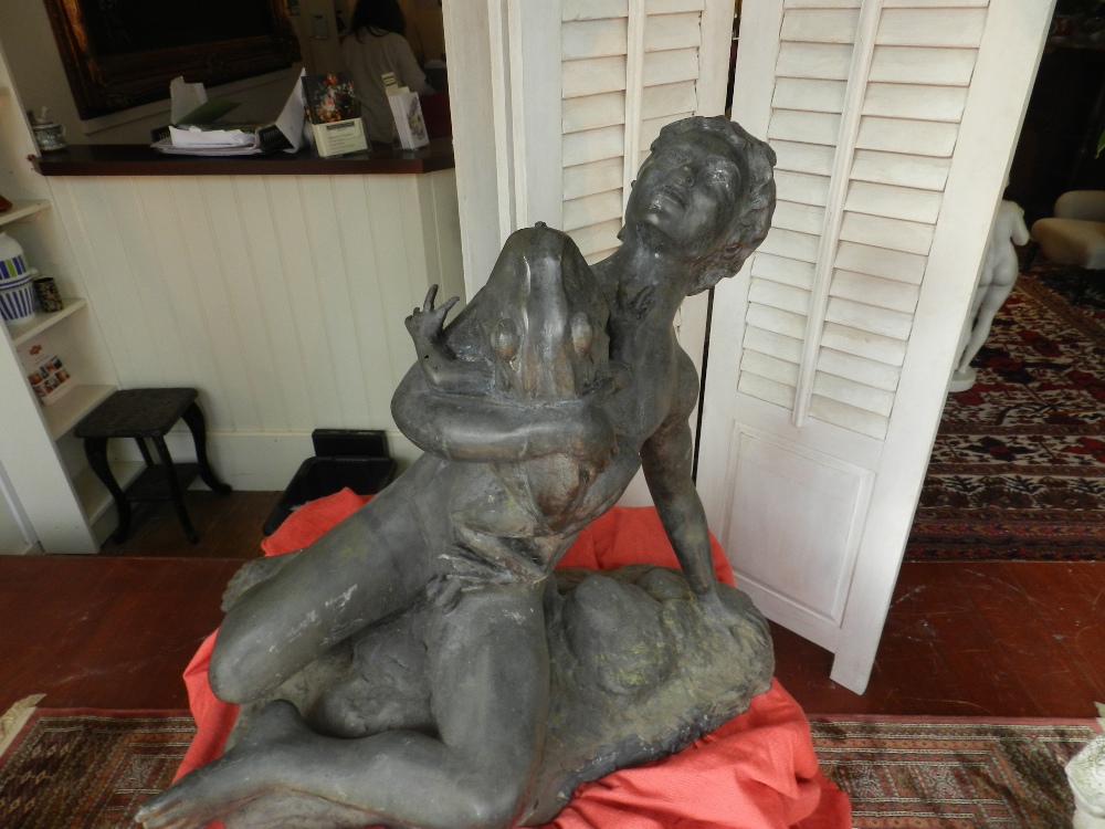 A bronze water fountain in the form of a boy clutching a frog.